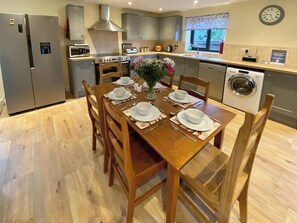 A modern kitchen with a dining area set for six. - 3 bedroom accommodation in Foxley, near Dereham (Foxley, near Dereham)