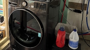 Un appareil combiné lave-linge et sèche-linge, de type « empilable », doté d’un panneau de commande, d’un miroir et d’un autocollant contenant un code QR.