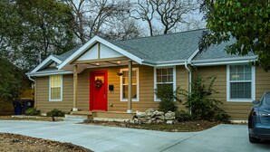 A two-story house with a red front door, a covered porch, and a garage.