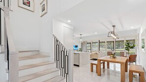 Un interior moderno con una escalera, un comedor y una cocina.