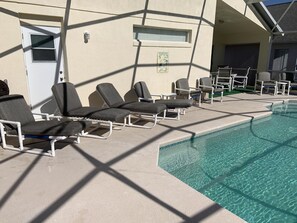 A poolside area with lounge chairs and a pool.