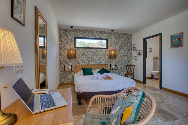 A bedroom with a bed, a laptop on a desk, a mirror, and a window. - LOU MIYA - Gîte Périgourdin 5kms from SARLAT, Air conditioning, Jacuzzi SPA WELLIS (Carsac-Aillac)