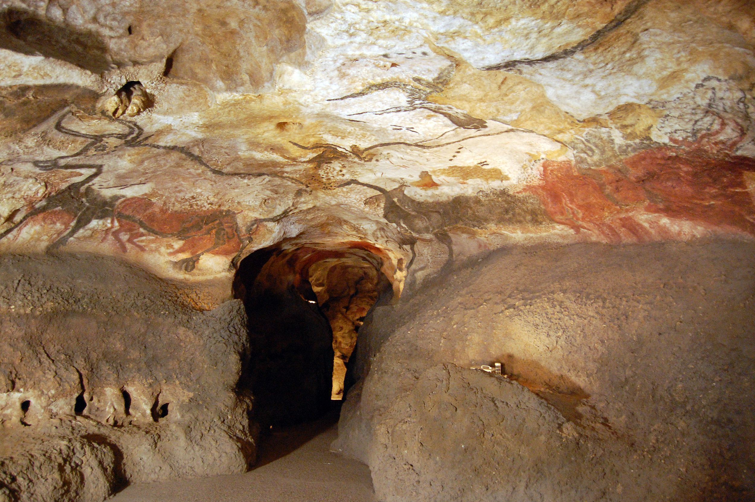 A cave interior with natural rock formations and a narrow passageway.