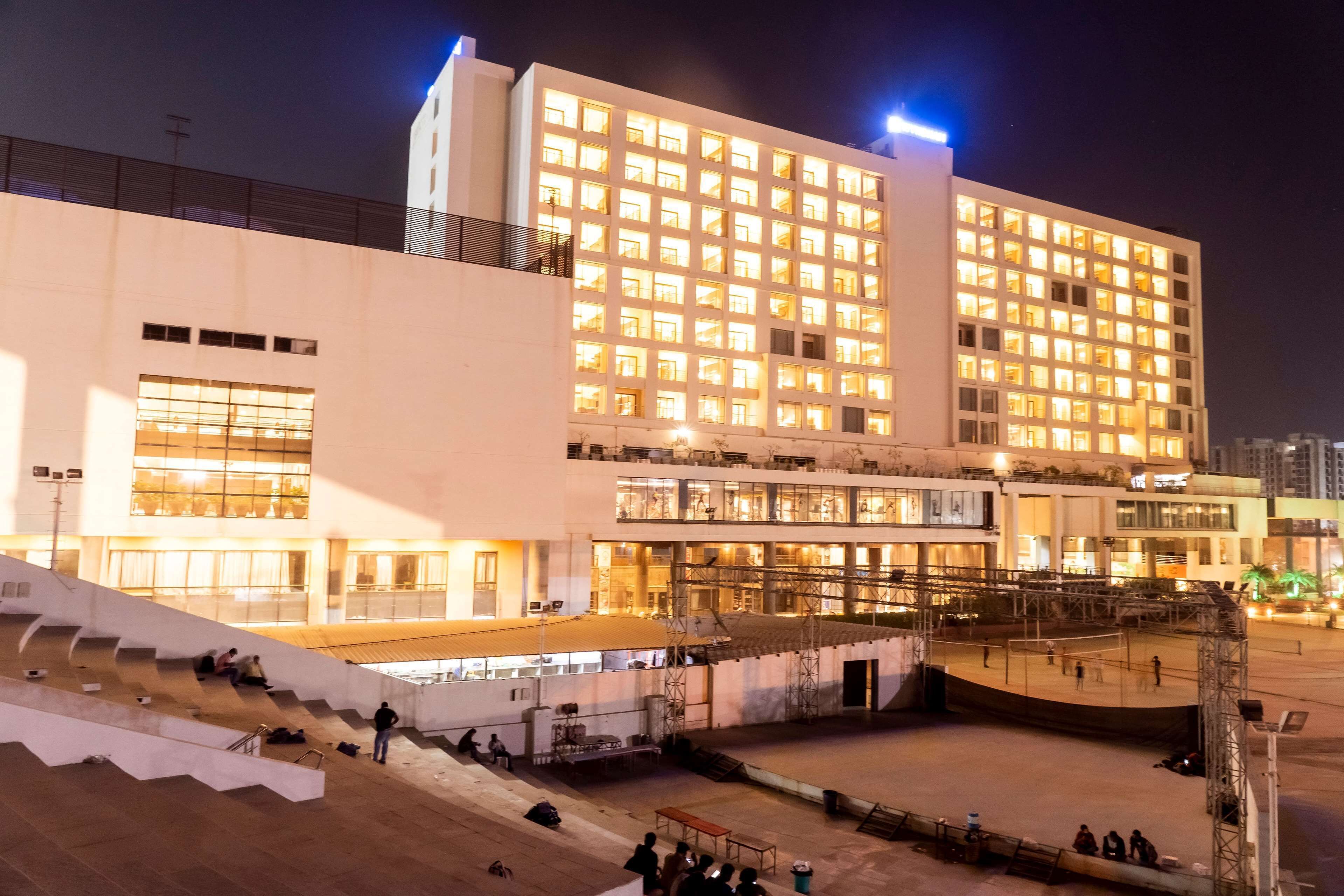 A multi-story hotel with a modern facade, large windows, and a central courtyard.
