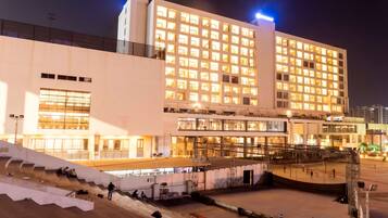 A multi-story hotel with a modern facade, large windows, and a central courtyard.