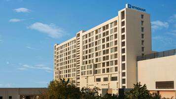 A multi-story hotel with a modern design, featuring a prominent 'WYNDHAM' sign on the top.
