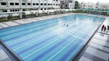 Kolam renang terbuka, kerusi lepak pantai, penyelamat di tapak hartanah