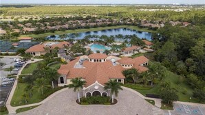 A large resort with a central pool, multiple villas, and a surrounding natural landscape. - Treviso Bay Condo on rarely available Top Floor (Naples)