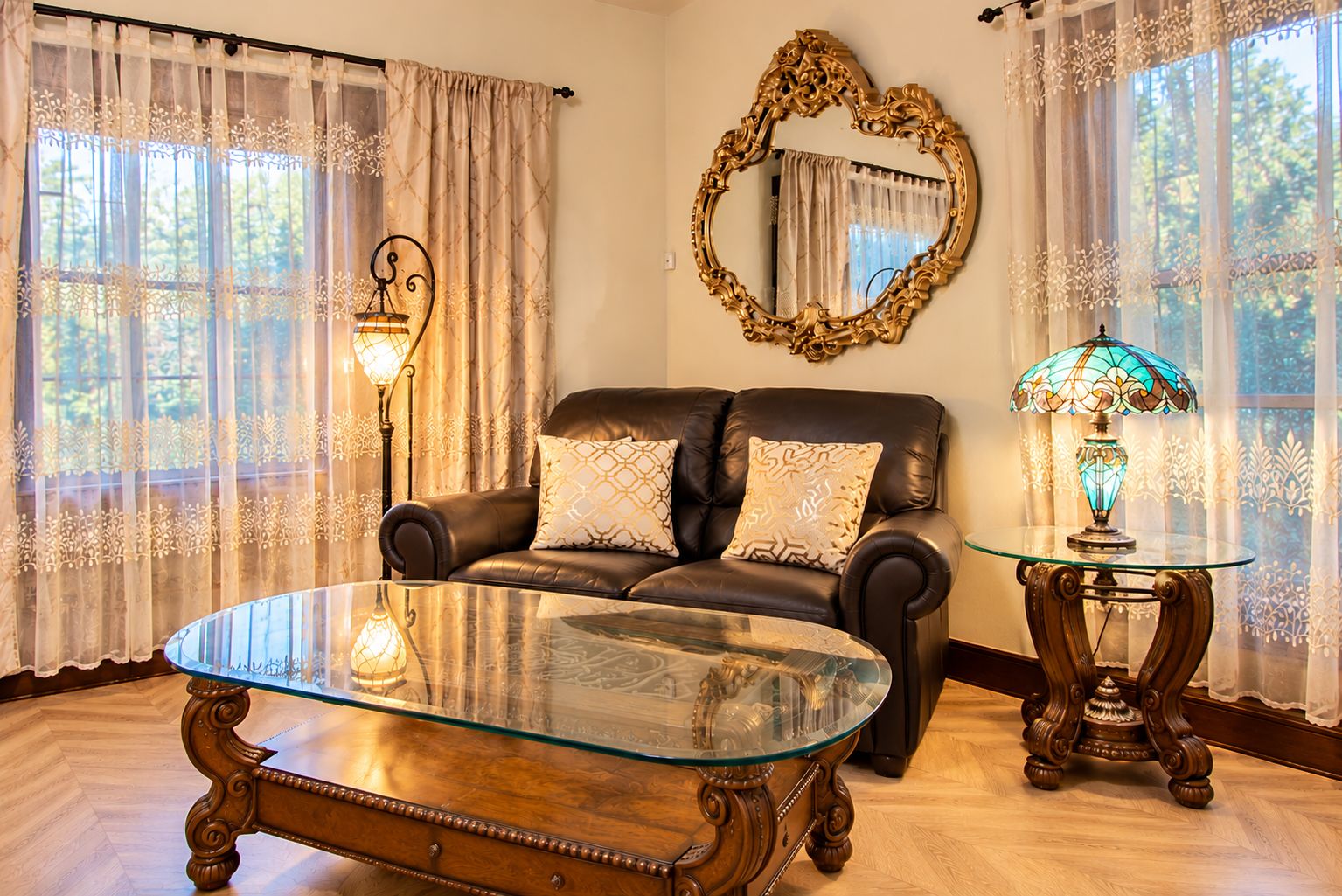 Un salon avec un canapé en cuir, une table basse en verre, un miroir et une lampe.
