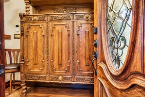 Une porte à deux battants en bois, ornée de sculptures complexes et dotée d’une serrure moderne.
