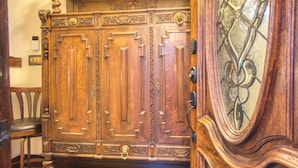 Une porte à deux battants en bois, ornée de sculptures complexes et dotée d’une poignée en laiton.