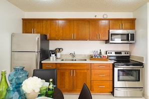 Enjoy cooking in this fully equipped kitchen with a refrigerator, stove, microwave, and sink.