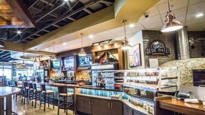 Een bar met een toonbank, zitplaatsen en een bord waarop 'BLUE WATER' staat.
