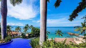 A tropical resort with a pool, palm trees, and a view of the ocean. - Beautiful Private Villa Beachfront Location, Full Staff & transfers included (Puerto Vallarta)