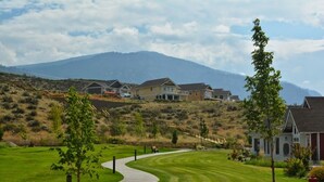 A residential area with houses, a winding driveway, and a mountain backdrop. - Peaceful, Modern Lake Cottage/A Sunny Retreat @ The Cottages on Osoyoos Lake 🌅 (Oliver)