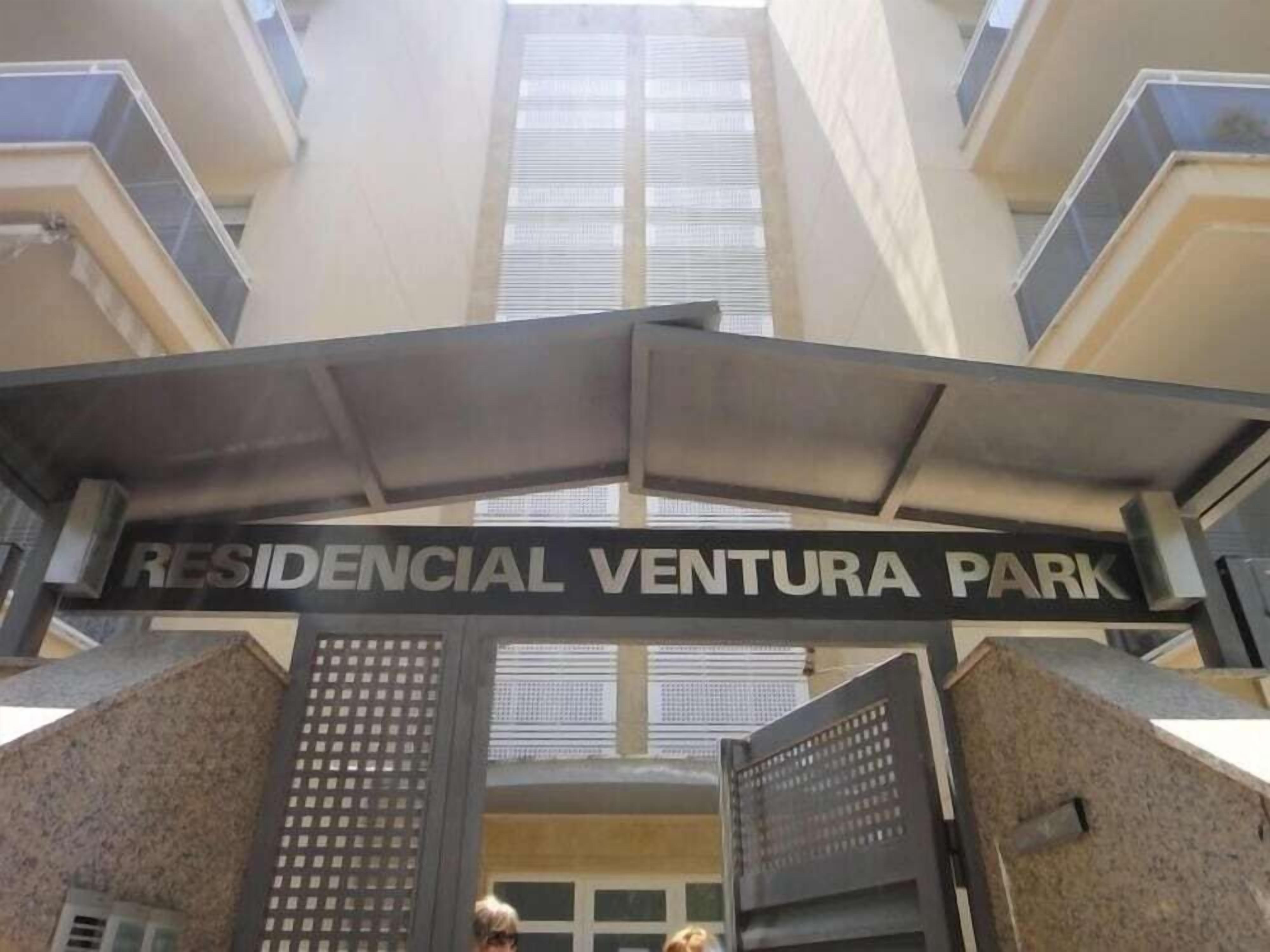 L’entrée du Residencial Ventura Park est marquée par un portail en métal et une enseigne placée au-dessus.