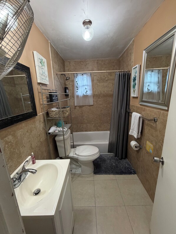 Een badkamer met een wastafel, toilet, bad en douchegordijn.