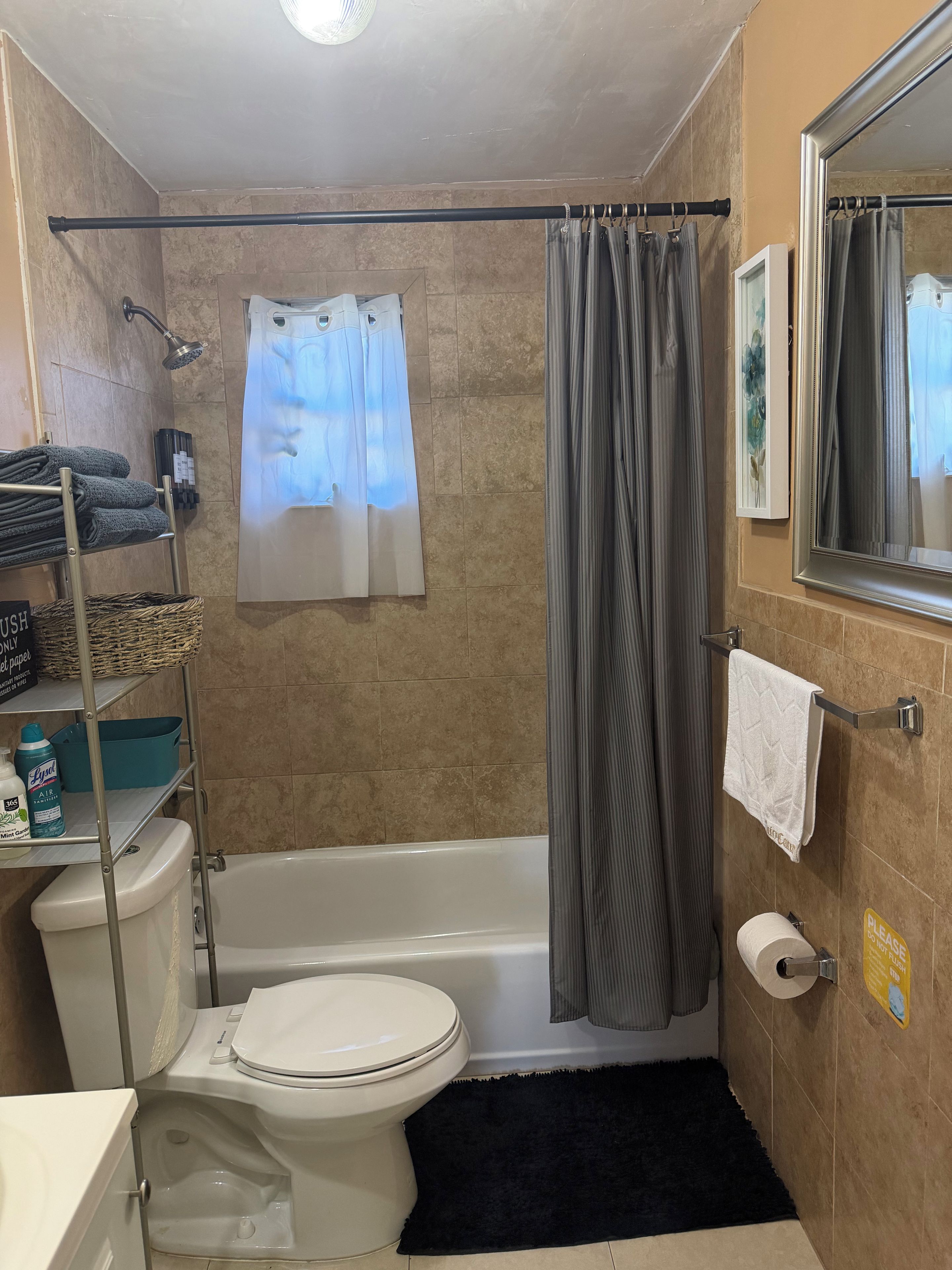 A bathroom with a bathtub, toilet, shower, and a towel rack.