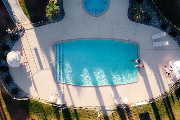 An aerial view of a swimming pool area with a circular hot tub, lounge chairs, and a small deck area. - Palm Desert Getaway: Pool*Sun*Fun*Best Location! (Palm Desert)