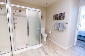 A modern bathroom with a glass-enclosed shower, a toilet, and a towel rack. - Palm Desert Getaway: Pool*Sun*Fun*Best Location! (Palm Desert)