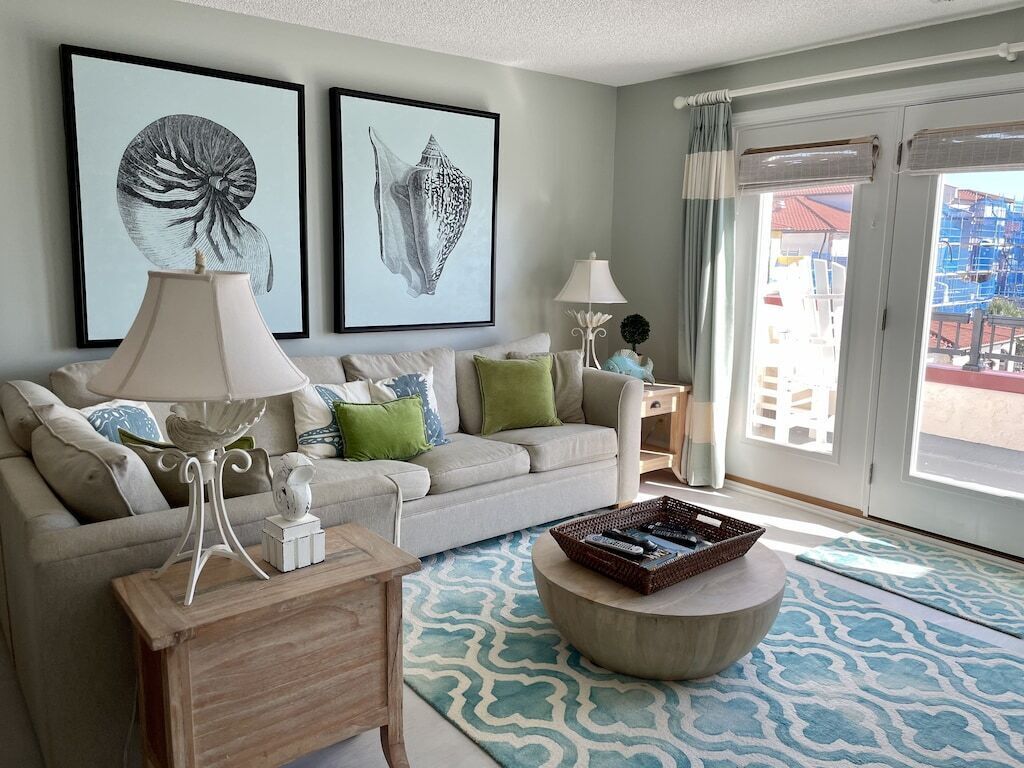 A living room with a sofa, two side tables with lamps, a coffee table, and artwork on the wall.