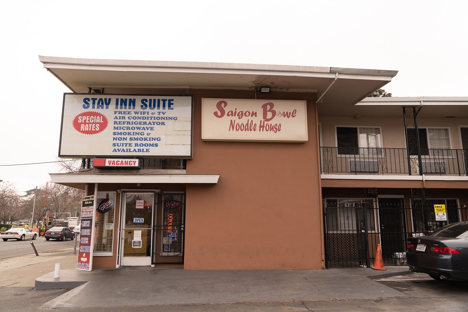 A Stay Inn Suite with amenities like free wifi, TV, air conditioning, refrigerator, microwave, smoking and non-smoking rooms, and vacancies. Adjacent is Saigon Bowe Noodle House.