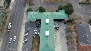 Vue aérienne d’un bâtiment doté d’un toit végétalisé, d’un parking et d’une route adjacente.