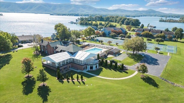 An aerial view of a large estate with a swimming pool, tennis courts, and a well-maintained lawn. - Moondance at BERNARD’S LANDING (moneta)
