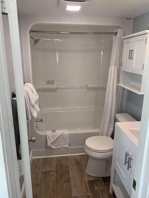 Un baño con bañera, inodoro y cabina de ducha.