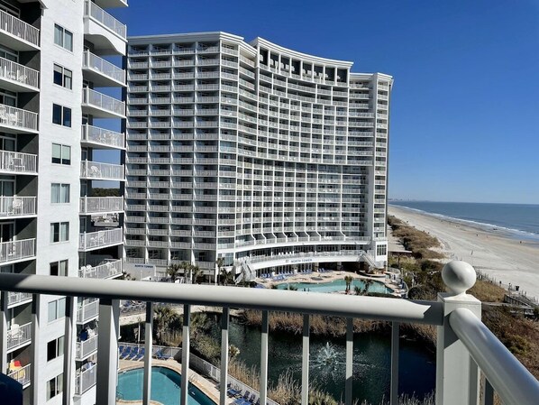 Un hôtel de grande hauteur doté de nombreux balcons, d’une piscine et offrant une vue sur la plage.
