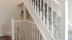 A staircase with white balusters and a patterned carpet. - 3 bedroom accommodation in Alnwick (Alnwick)