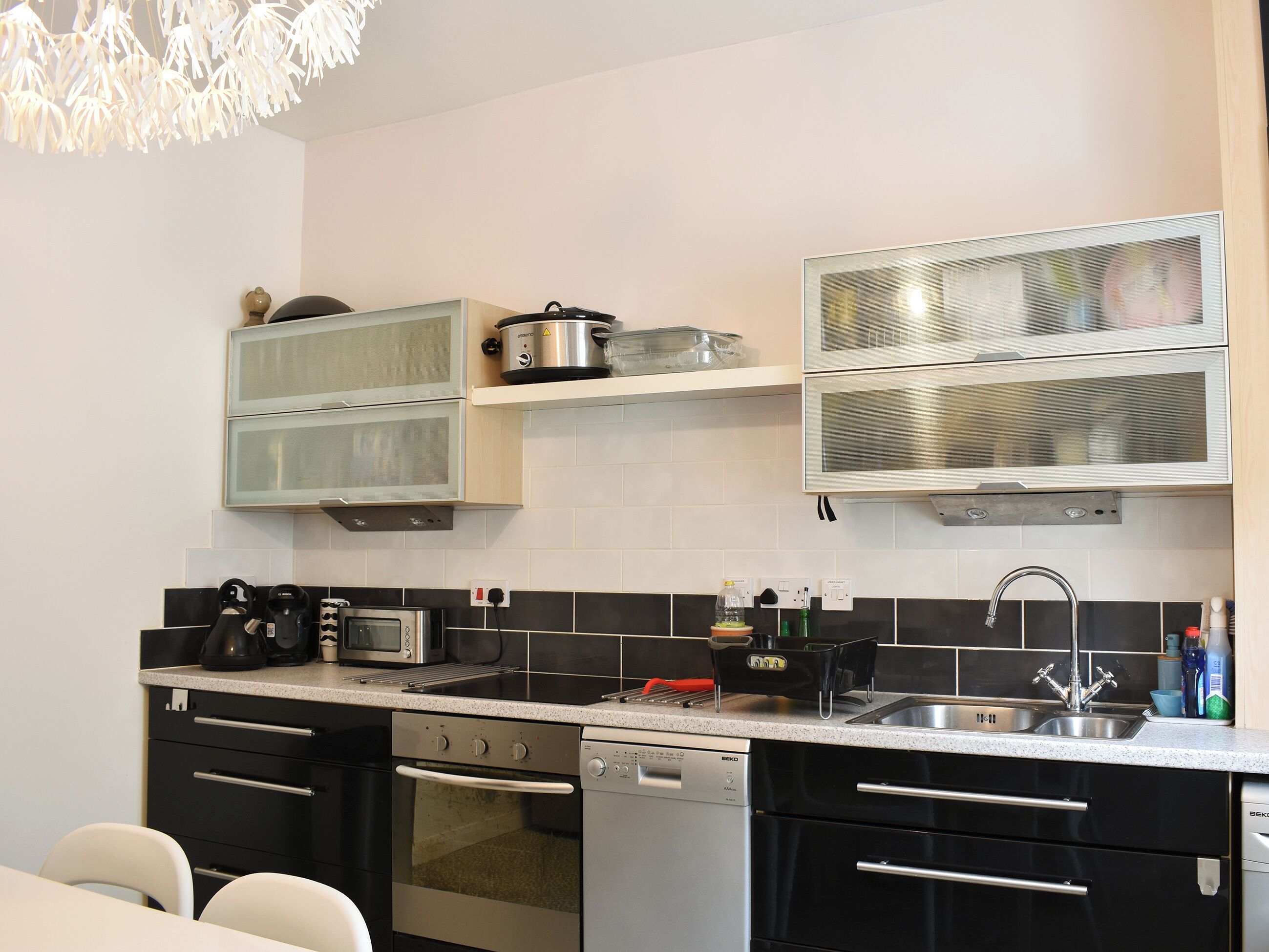 A modern kitchen with stainless steel appliances, a microwave, a toaster, and a dishwasher.
