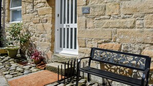 A stone building with a white door labeled "37C" and a "UP NORTH" sign. - 3 bedroom accommodation in Alnwick (Alnwick)