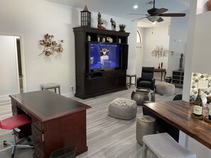 Relax in this inviting living room with a flat-screen TV, dining area, and comfortable seating.