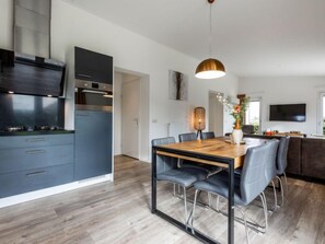 Una cocina moderna con armarios oscuros y una mesa de comedor de madera.