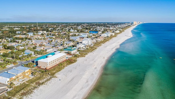 An aerial view of a coastal town with a long beach, clear blue waters, and a mix of residential and commercial buildings. - 1 minute to beach 6 BR 5 baths private heated pool Games Sleeps 2-19 (Panama City Beach)