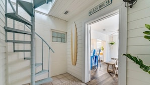 A staircase leading to a room with a surfboard and a sign reading "BEACH HOUSE". - 1 minute to beach 6 BR 5 baths private heated pool Games Sleeps 2-19 (Panama City Beach)