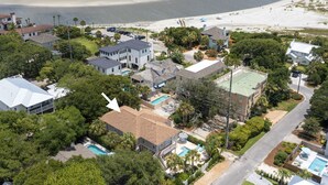 An aerial view of a coastal residential area with houses, a beach, and a swimming pool. - Blue Star Bungalow steps to the Beach with Heated Pool, sleeps 8 (Saint Simons Island)