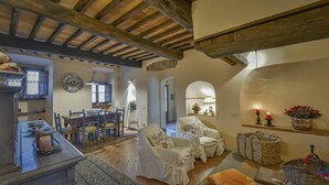 A cozy living room with a fireplace, a dining area, and a kitchen. - Villa with Pool in Tuscany for 8 People (Cantagrillo)