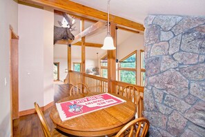 A dining area with a round wooden table, chairs, and a mounted moose head. - Dramatic Mountain Views,Downtown, Luxury Home,RMNP,Hot Tub! Little Prospect Mtn Home, Estes Park CO (Estes Park)