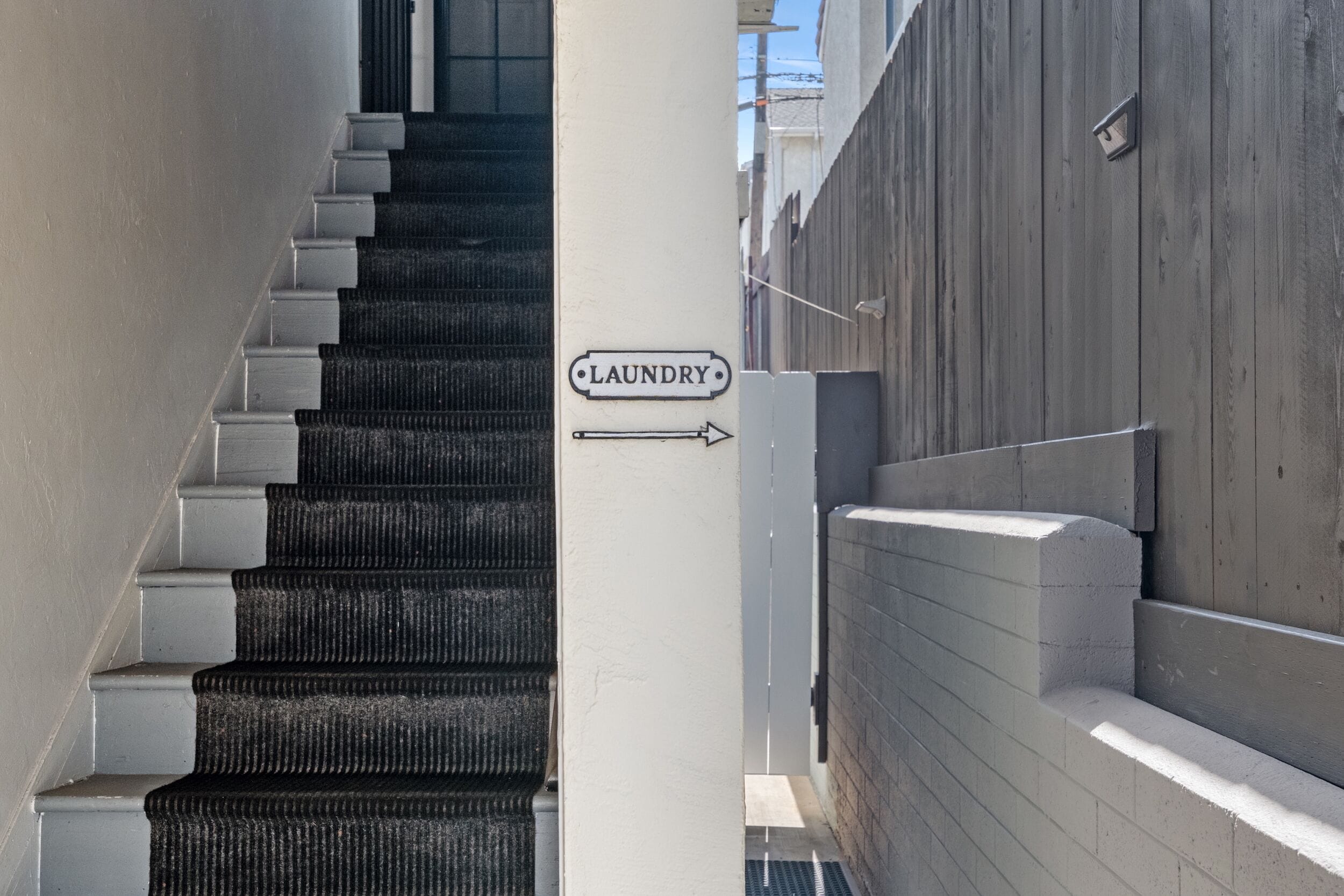 Eine Treppe mit einem Schild, das den Weg zur Wäscherei weist.