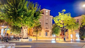 A public square with a building featuring a clock tower, surrounded by trees and outdoor seating. - Villa Leca Pool and Sauna (Vinodol)