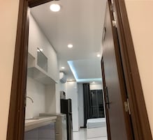Una cocina moderna con armarios blancos, un lavamanos de acero inoxidable y un refrigerador negro.