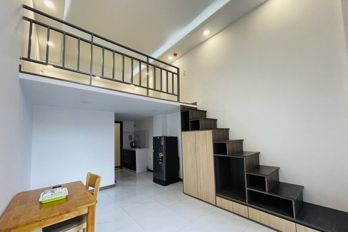 Um apartamento moderno com área de jantar, cozinha e escada para um andar superior.
