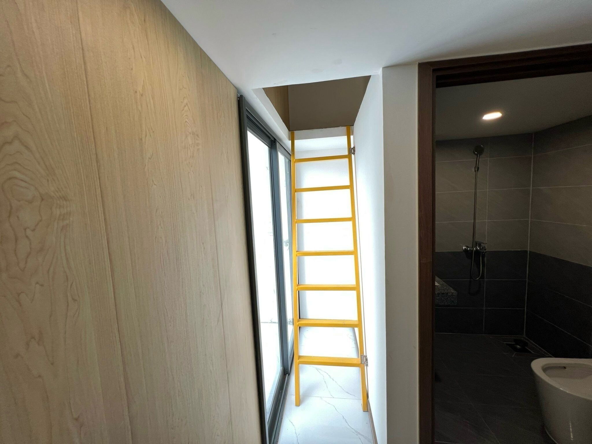 Une salle de bain avec une douche, des toilettes et un mur en bois.