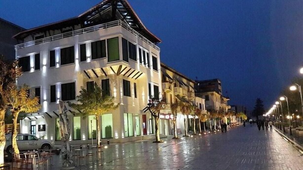 A multi-story building with a modern design, featuring large windows and a flat roof. - White City (Berat)