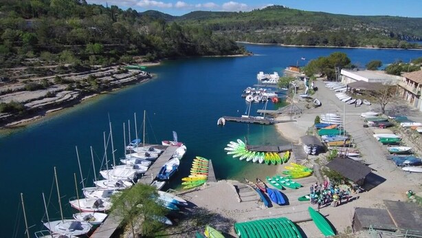 Un port de plaisance avec des bateaux amarrés, un petit quai et un bâtiment doté d’un toit en pente.