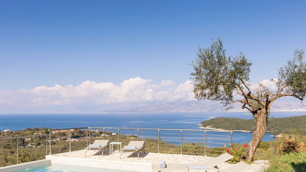 Area piscina con lettini e vista sul mare.
