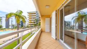 A balcony with a pool view, a sliding glass door, and a tiled floor. - Aidan Apartment by LovelyStay (Funchal)