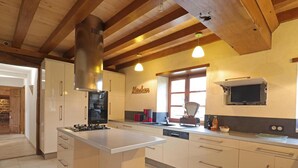Een moderne keuken met een centraal eiland, een ingebouwde oven en een groot raam.